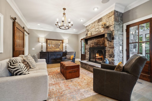 living room featuring a notable chandelier, a barn door, a stone fireplace, and light wood-type flooring