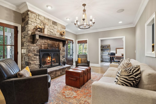 living room with light hardwood / wood-style floors, crown molding, a fireplace, and a chandelier