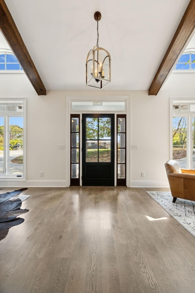 entryway with a chandelier, beam ceiling, and hardwood / wood-style floors