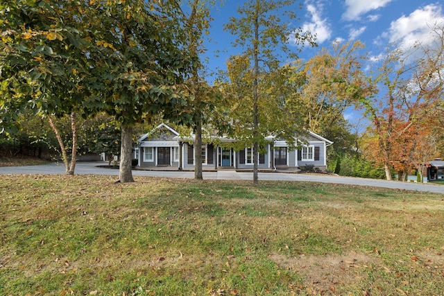 view of property hidden behind natural elements with a front lawn