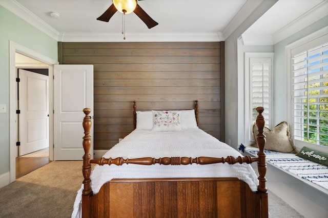 bedroom featuring carpet flooring, ceiling fan, wood walls, and crown molding