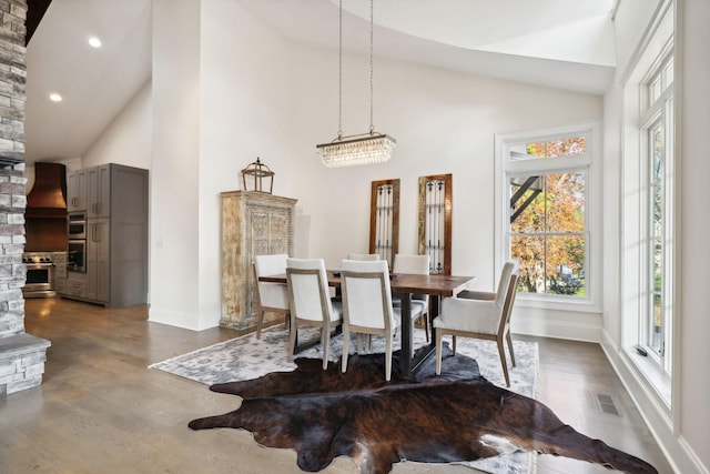 dining room with a notable chandelier, dark hardwood / wood-style floors, and high vaulted ceiling