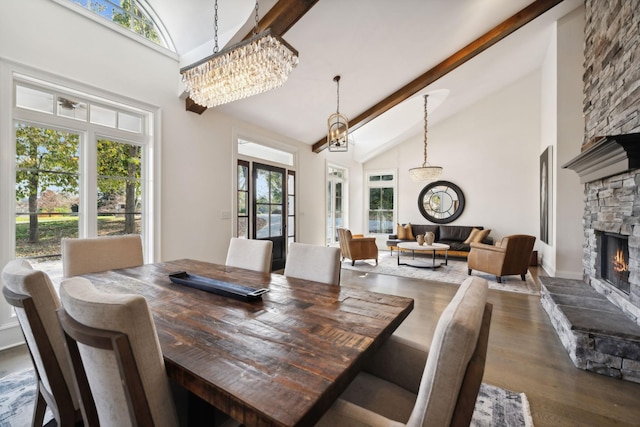 dining room featuring high vaulted ceiling, a stone fireplace, dark hardwood / wood-style floors, beamed ceiling, and a notable chandelier