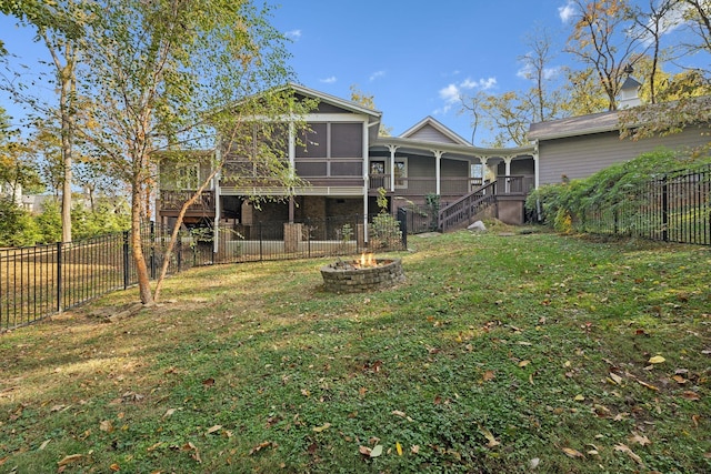 back of house featuring a lawn and a sunroom