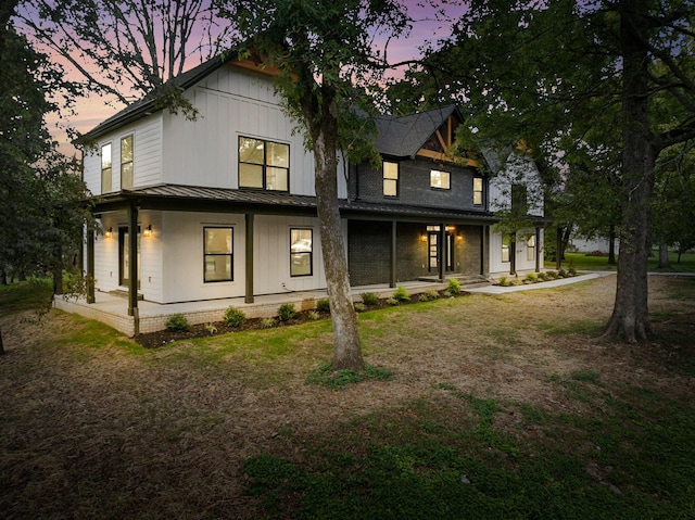 back house at dusk with a porch