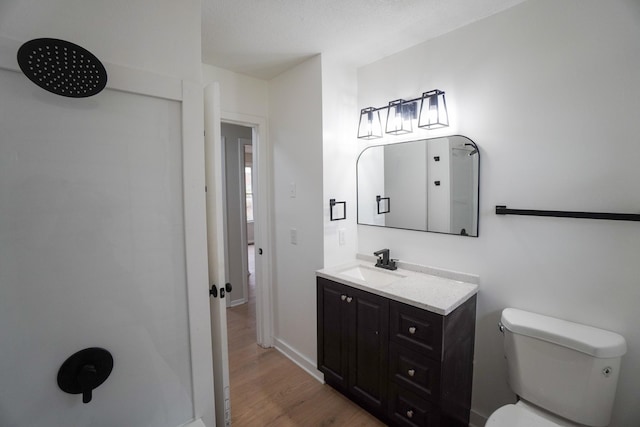 bathroom featuring hardwood / wood-style floors, vanity, and toilet