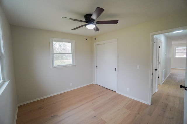 unfurnished bedroom with ceiling fan, a closet, and light hardwood / wood-style flooring