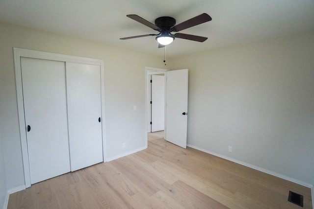 unfurnished bedroom with a closet, light hardwood / wood-style flooring, and ceiling fan