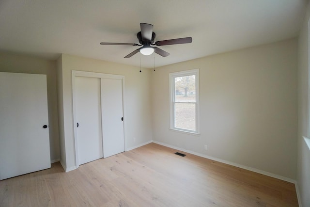 unfurnished bedroom with light wood-type flooring, a closet, and ceiling fan