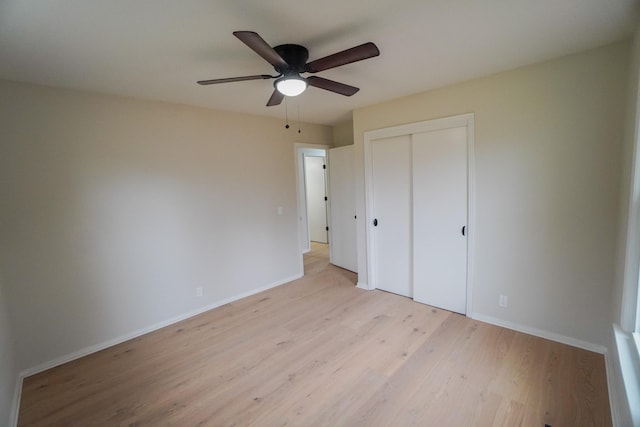 unfurnished bedroom featuring a closet, light hardwood / wood-style flooring, and ceiling fan