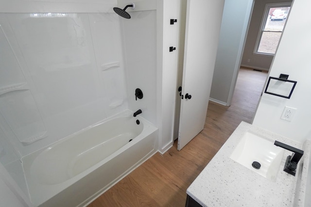 bathroom with hardwood / wood-style floors, vanity, and shower / tub combination