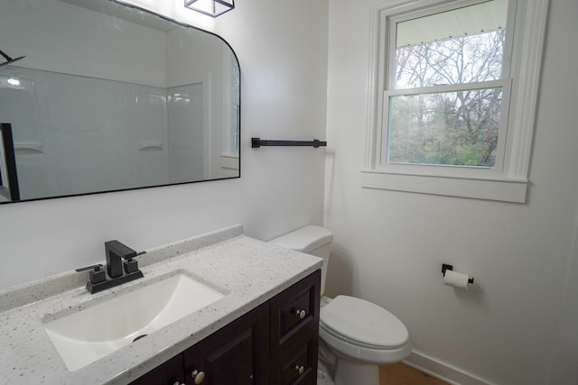 bathroom featuring walk in shower, vanity, and toilet