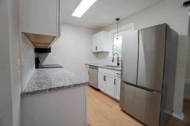 kitchen with white cabinets, pendant lighting, sink, and appliances with stainless steel finishes