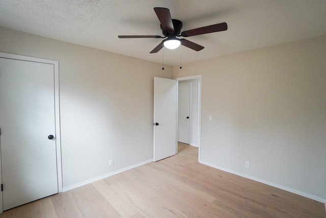 unfurnished bedroom featuring ceiling fan, light hardwood / wood-style floors, and a textured ceiling