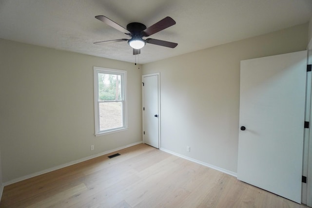 spare room featuring light wood-type flooring and ceiling fan