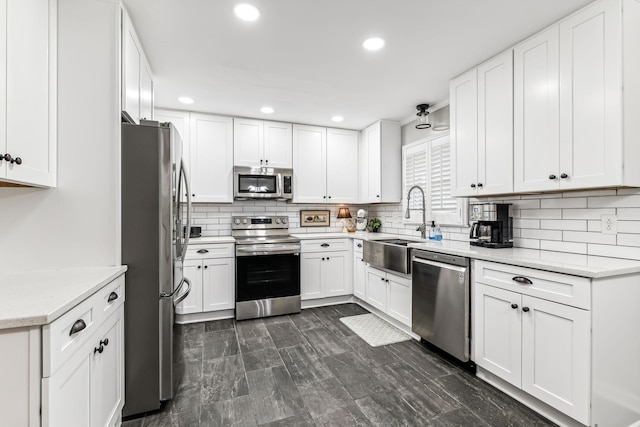 kitchen featuring white cabinets, decorative backsplash, light stone countertops, and stainless steel appliances