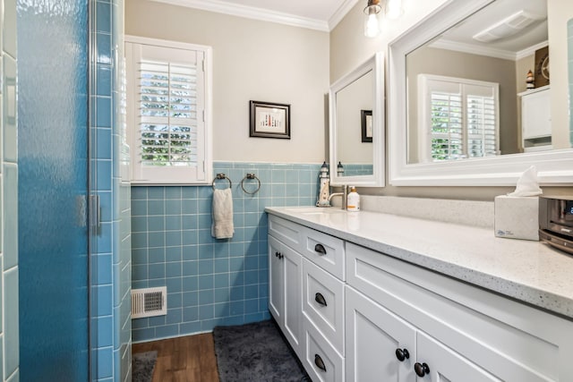 bathroom featuring hardwood / wood-style flooring, vanity, crown molding, and tile walls