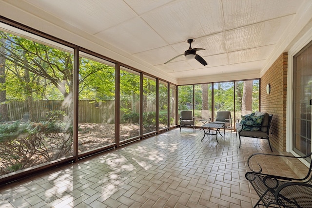 unfurnished sunroom featuring ceiling fan