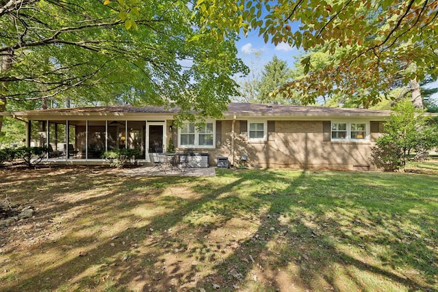 back of house with a lawn, a sunroom, and a patio