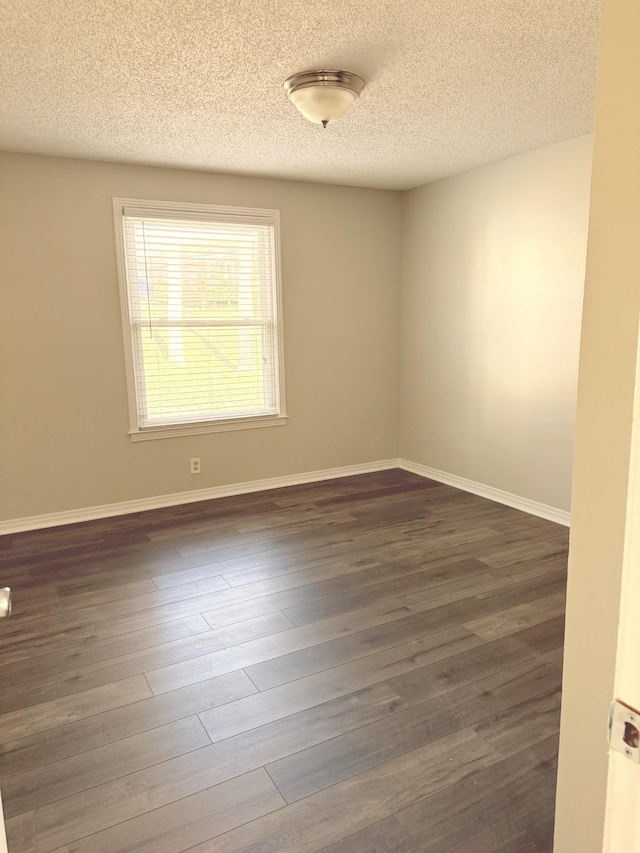 unfurnished room with dark hardwood / wood-style floors and a textured ceiling