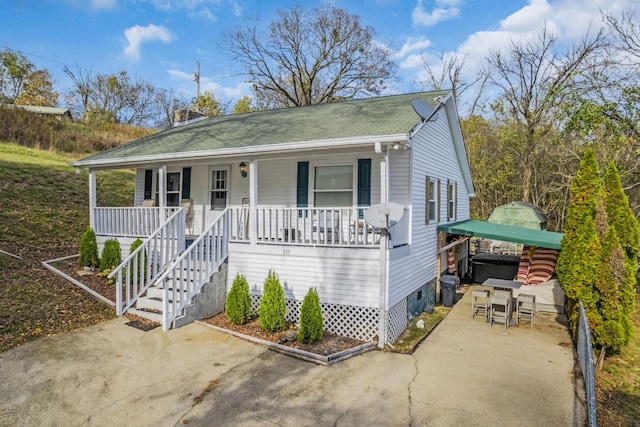 view of front of house featuring covered porch and a hot tub