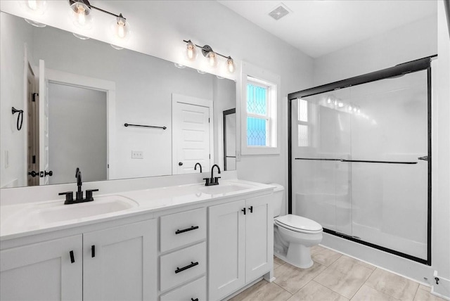 bathroom featuring vanity, toilet, and an enclosed shower