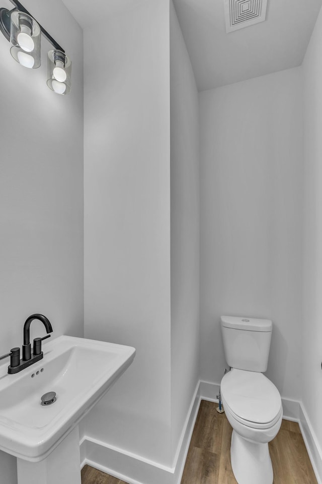 bathroom featuring hardwood / wood-style flooring, sink, and toilet