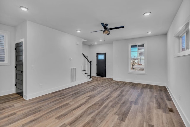 unfurnished living room featuring ceiling fan and light wood-type flooring