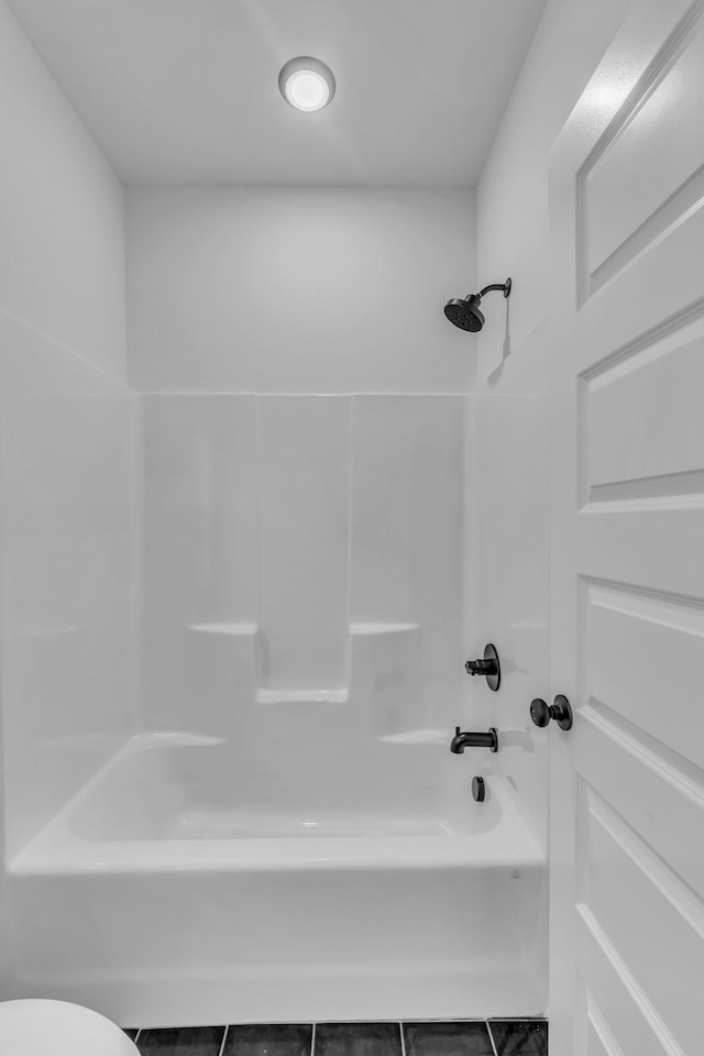 bathroom featuring shower / tub combination and toilet