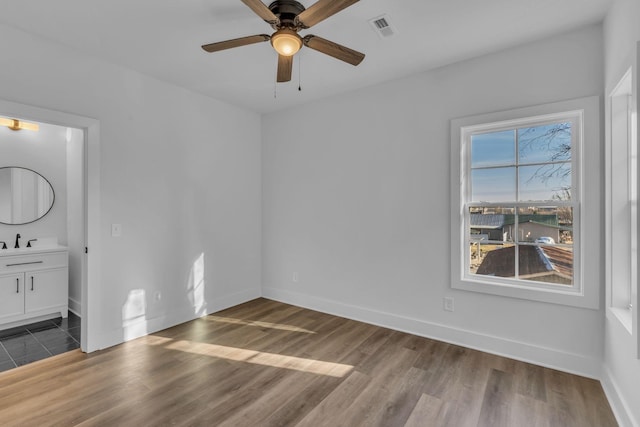 empty room featuring ceiling fan, sink, and hardwood / wood-style floors