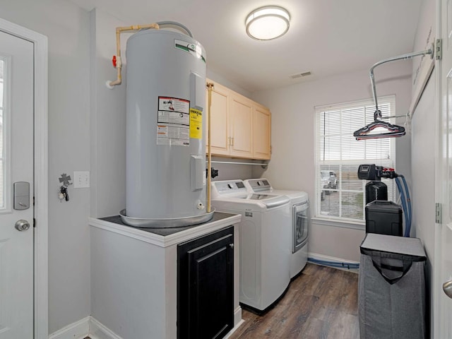 laundry room featuring washer and clothes dryer, dark hardwood / wood-style floors, cabinets, and water heater