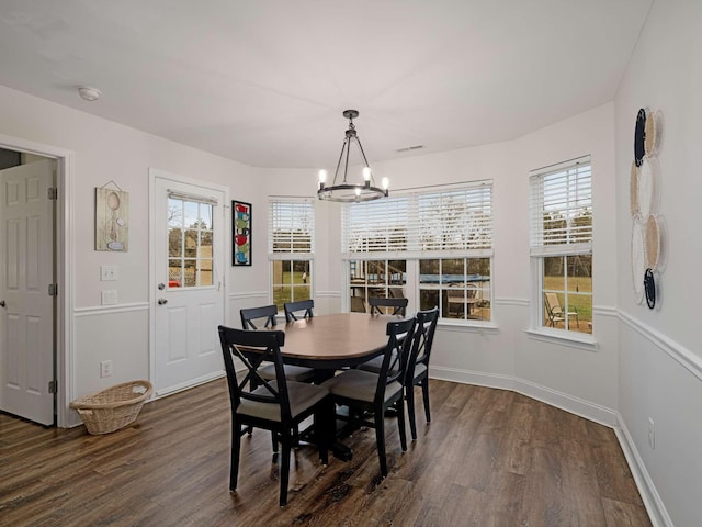 dining space with a chandelier, plenty of natural light, and dark wood-type flooring