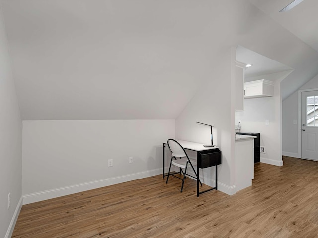 office with vaulted ceiling and light hardwood / wood-style flooring