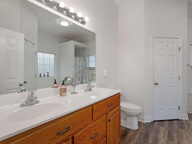 bathroom featuring toilet, vanity, and hardwood / wood-style flooring