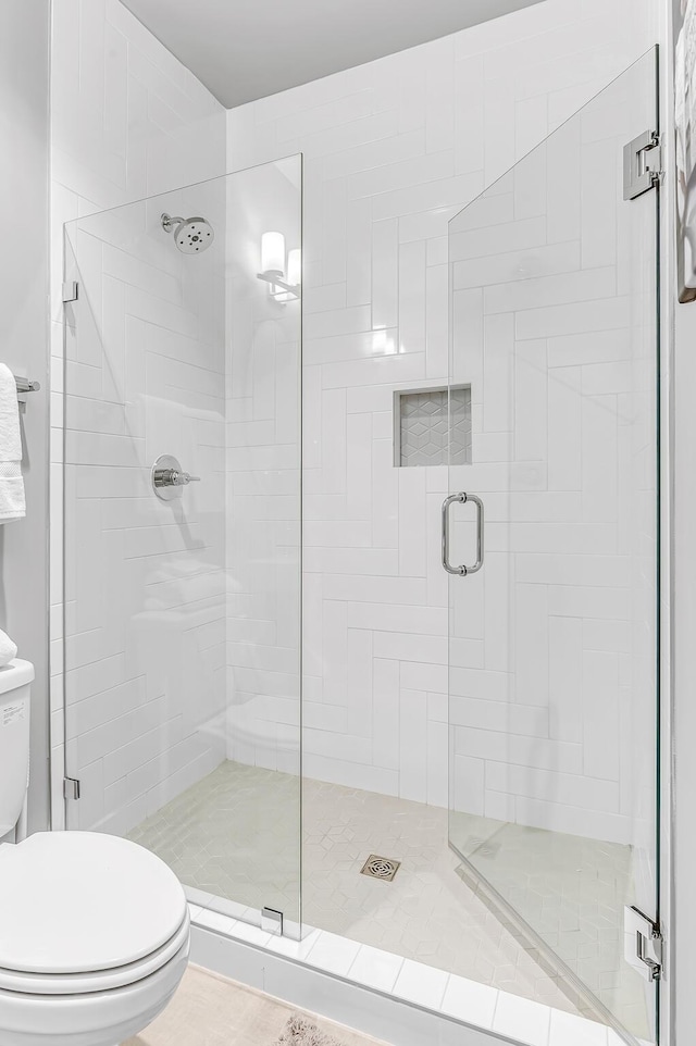 bathroom with an enclosed shower and toilet