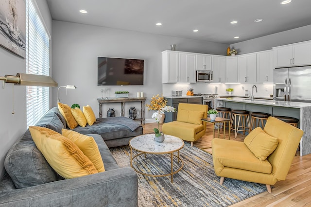 living room with sink and light wood-type flooring