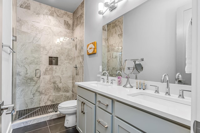 bathroom with toilet, tile patterned flooring, vanity, and walk in shower