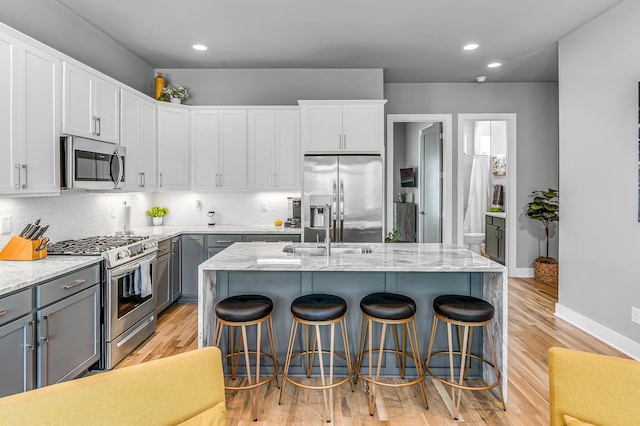 kitchen with appliances with stainless steel finishes, a center island with sink, and sink