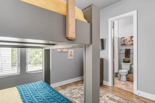 bedroom with wood-type flooring and ensuite bath