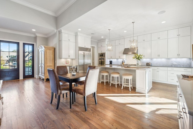 dining room featuring crown molding, sink, and wood-type flooring