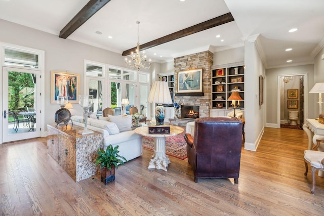 living room featuring built in features, a notable chandelier, beamed ceiling, light hardwood / wood-style floors, and a stone fireplace