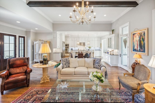 living room featuring crown molding, an inviting chandelier, and hardwood / wood-style flooring