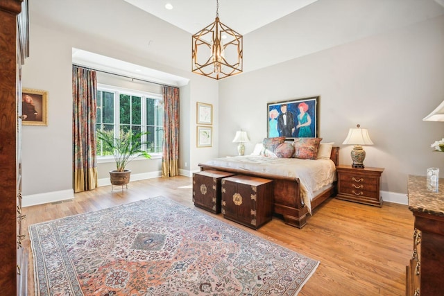 bedroom featuring a notable chandelier and light wood-type flooring