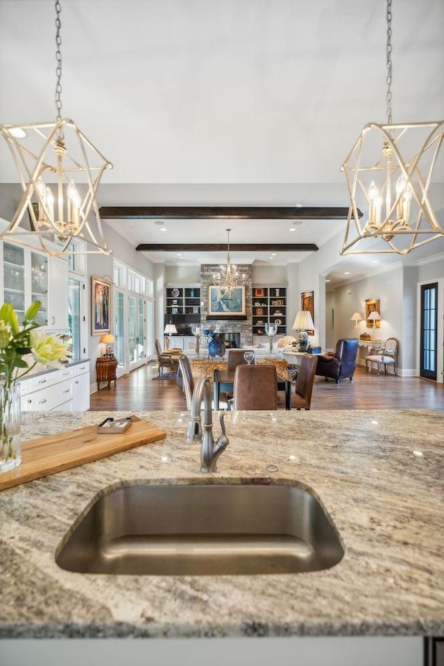 kitchen with beam ceiling, sink, and hanging light fixtures