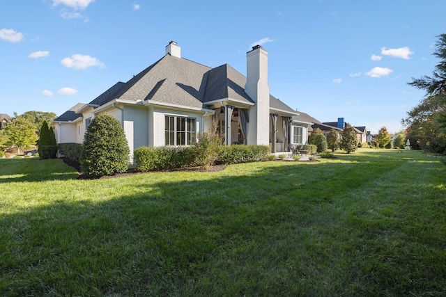 rear view of house featuring a yard