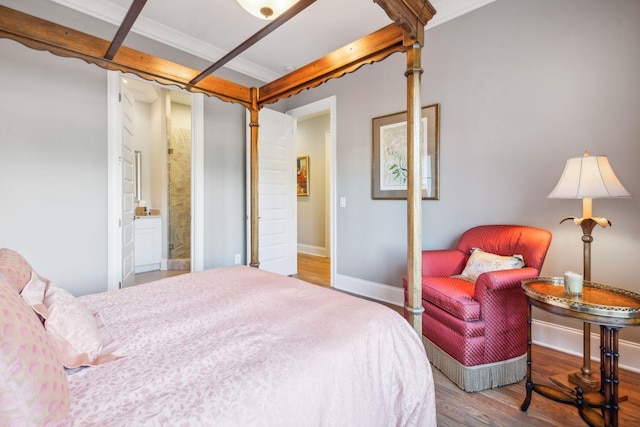 bedroom featuring ensuite bath, hardwood / wood-style flooring, and ornamental molding