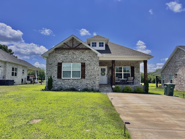 craftsman-style home featuring covered porch, central air condition unit, and a front yard