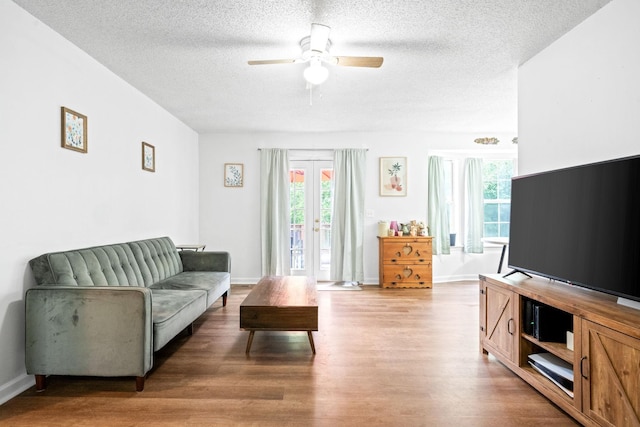 living room with hardwood / wood-style floors, ceiling fan, a textured ceiling, and french doors