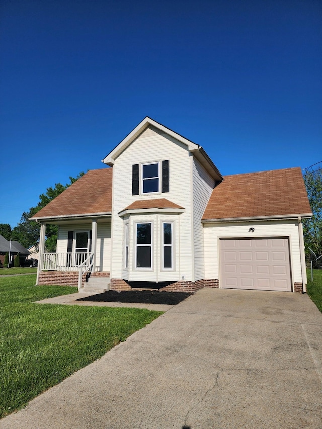 view of front of house featuring a front yard, a garage, and covered porch