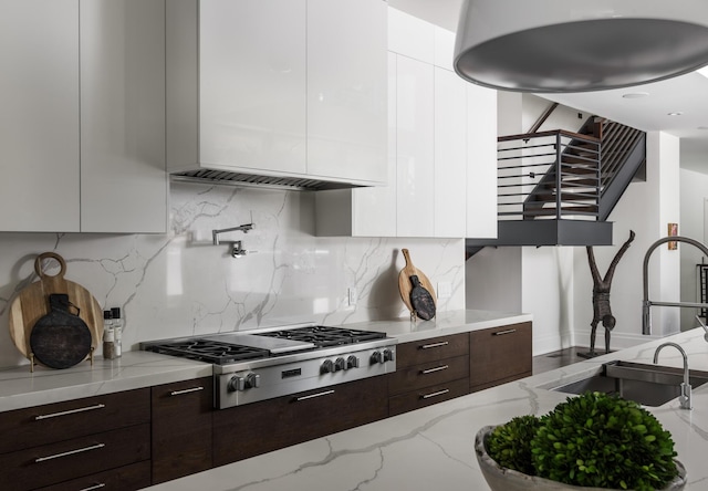 kitchen featuring light stone countertops, white cabinetry, and stainless steel gas cooktop